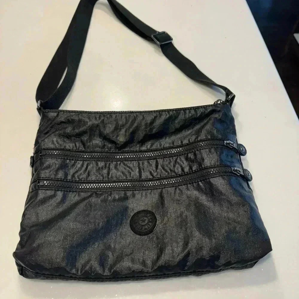 Kipling crossbody black bag. 4 zip compartments, adjustable strap